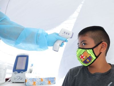 A boy has his temperature checked as he receives a free COVID-19 test in Los Angeles.
